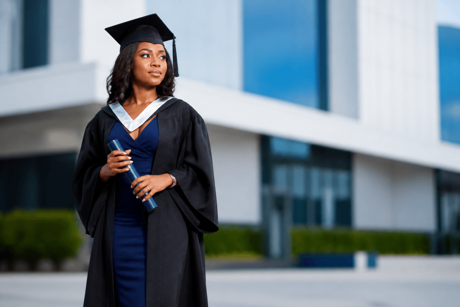 Graduate in academic gown on campus