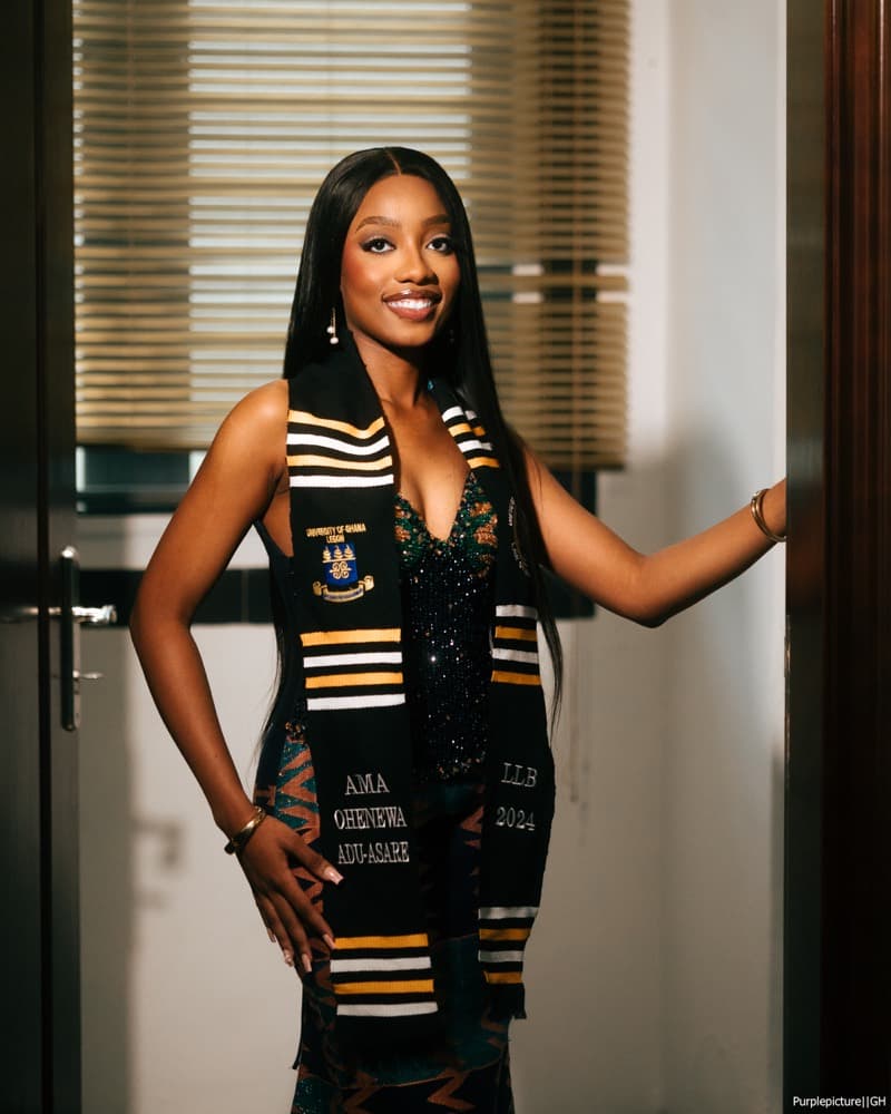 Graduate in a doorway wearing a university stole