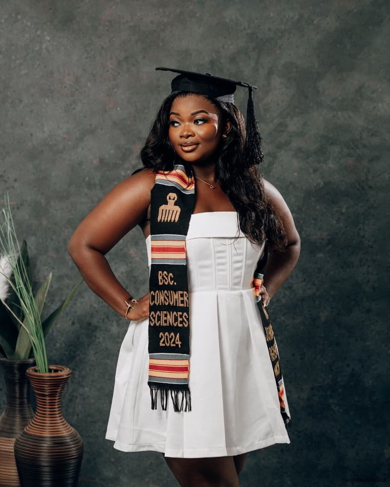 Graduate in a white dress and kente stole