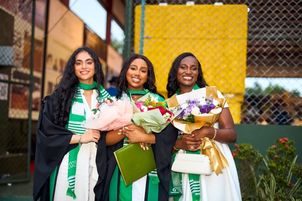 Three graduates with bouquets after the ceremony